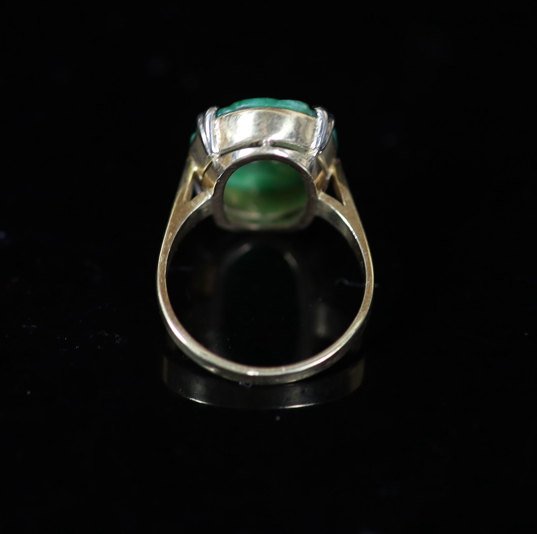 A mid 20th century gold and carved oval jade set dress ring